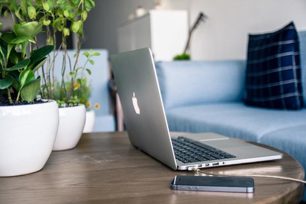 notebook a mobil položené na stolíku v obývačke
